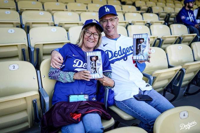 Dodger fans hold up their Mookie Betts bobbleheads.