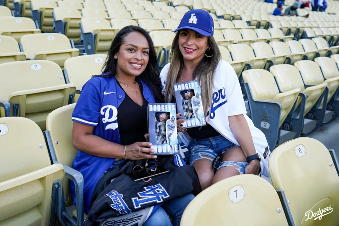 Dodger fans hold up their Mookie Betts bobbleheads.