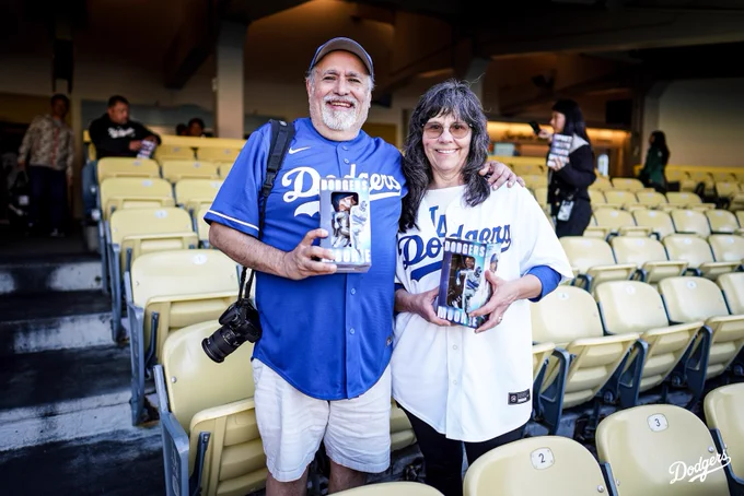 Dodger fans hold up their Mookie Betts bobbleheads.