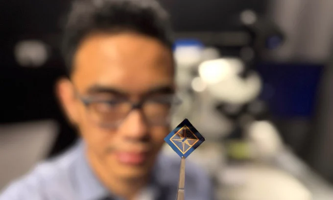 RMIT PhD scholar and study first author Thiha Aung inspects the team's neuromorphic vision device.