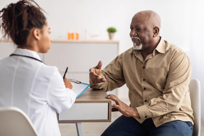 Photo of man talking to doctor