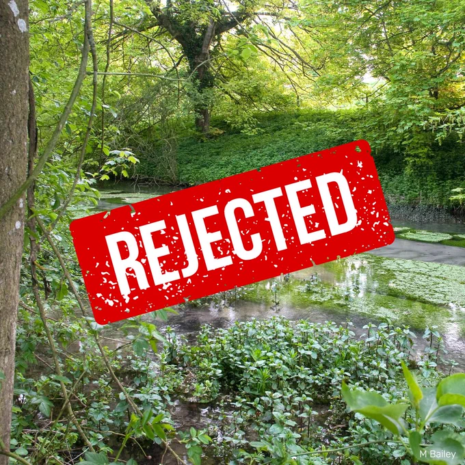 A clear chalk stream surrounded by lush green vegetation. In the middle of the image is a large red 'REJECTED' stamp.