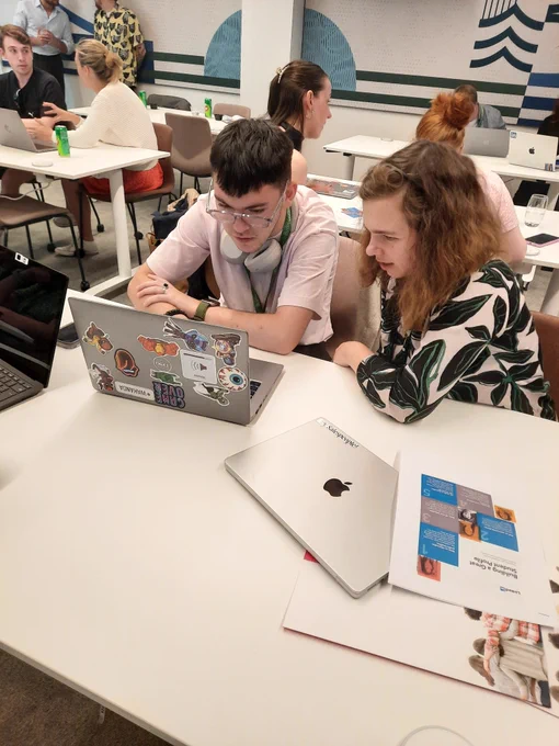 A mentor from LinkedIn working with a student from TCPID. Both are sitting at a desk and looking at a computer. 