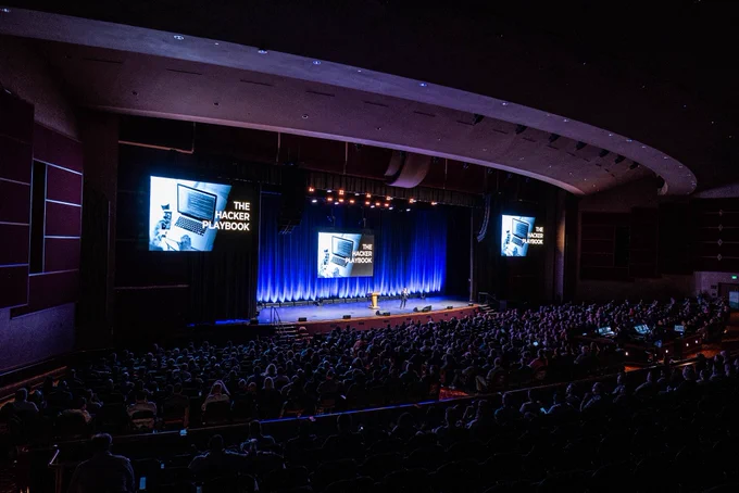 Rachel on a large stage with 800 in audience presenting on The Hacker Playbook
