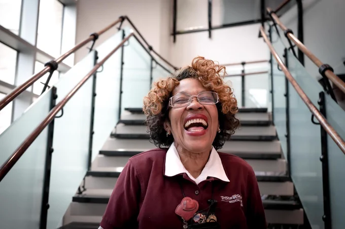 HCA Healthcare colleague Faye Duke smiling on hospital hallway stairs