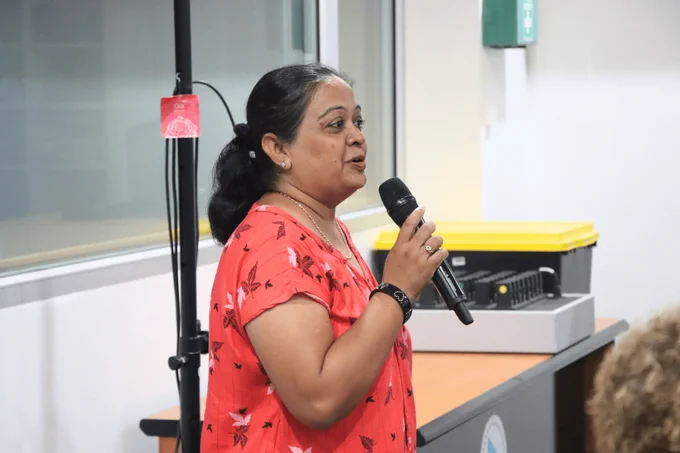 A participant giving a vote of thanks using a microphone at the end of the final session of the Assessment Instrument Development Micro-Qualification training.