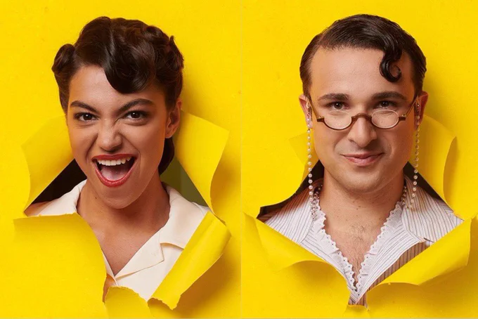 A photo showing two individuals sticking their heads through yellow paper