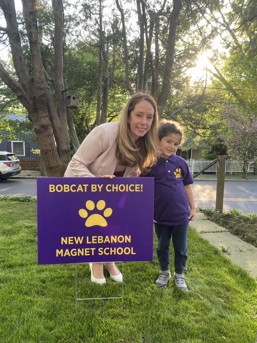Woman with young boy next to a sign that says bobcats by choice new Lebanon magnet school.