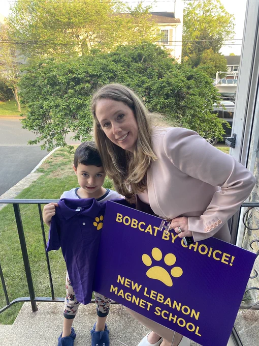 Woman with young boy next to a sign that says bobcats by choice new Lebanon magnet school.
