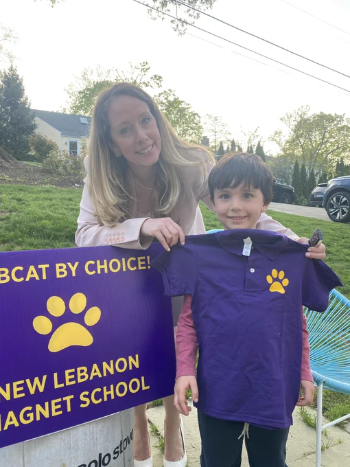 Woman with young boy next to a sign that says bobcats by choice new Lebanon magnet school.
