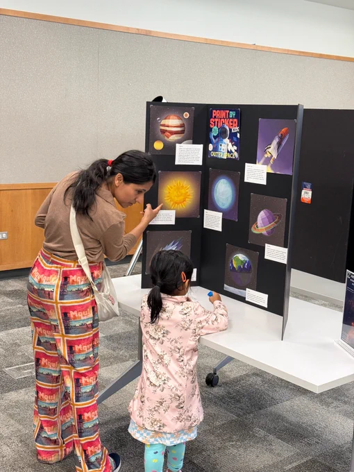A mother and her daughter checking out an Astronomy display