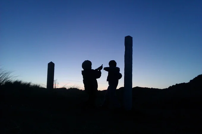 two boys on the beach with light sabres