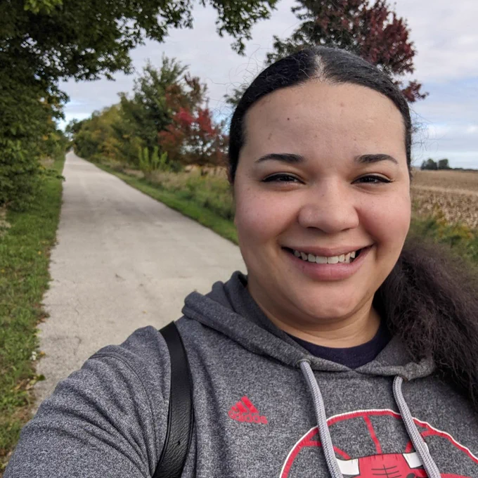 Dominque posing with a hiking trail in the background.