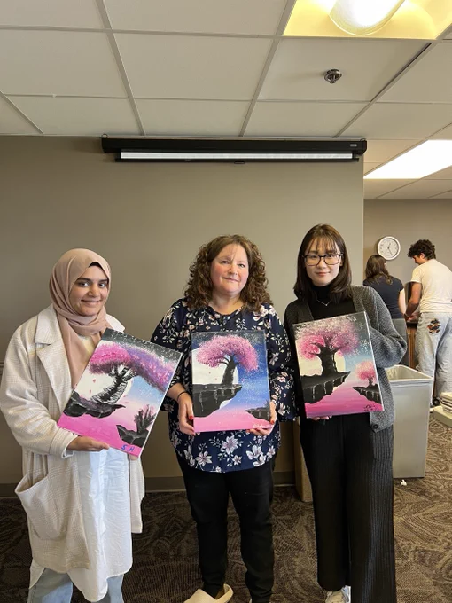 3 people holding up their paintings