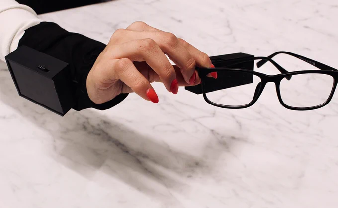 Person holding HapWare glasses with bright pink nails