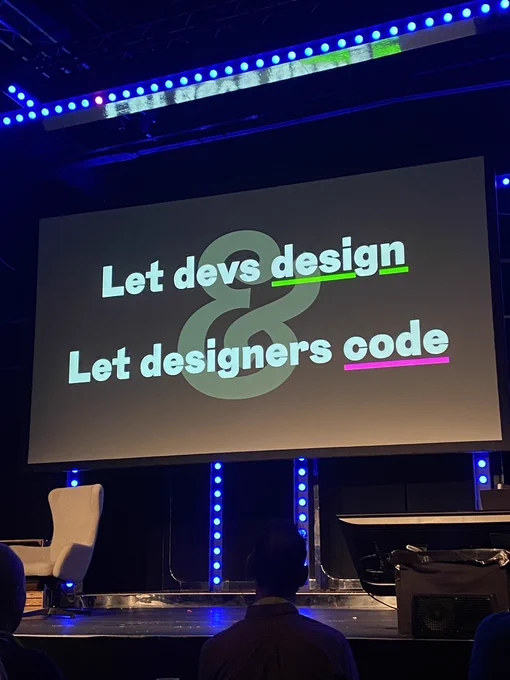 A screen displaying the text "Let devs design & Let designers code" in a bold, modern font.