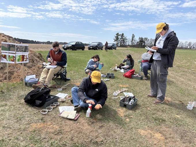 Students analyzing soil samples and landscape features