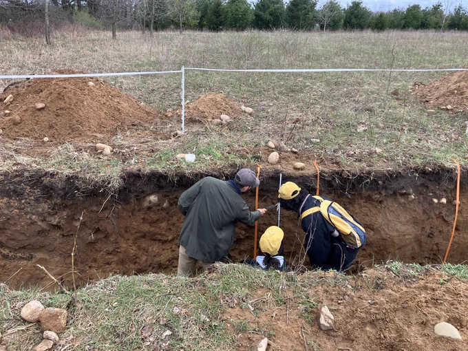 Students pointing out soil features in soil pit