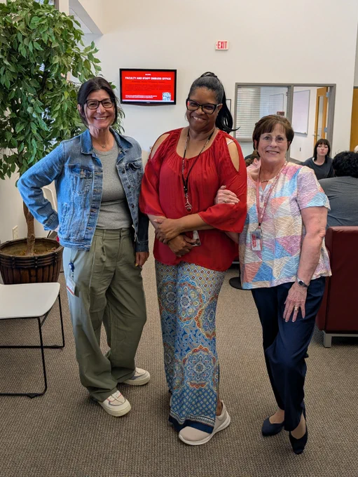 Three staff members pose for a photo.