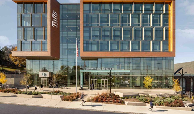 The Tufts University Cummings Center, which houses the Computer Science Department. It's a modern glass office building featuring the university logo.