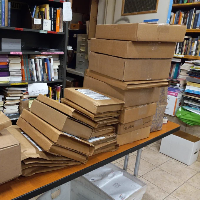 Stacks of books in boxes on a table.