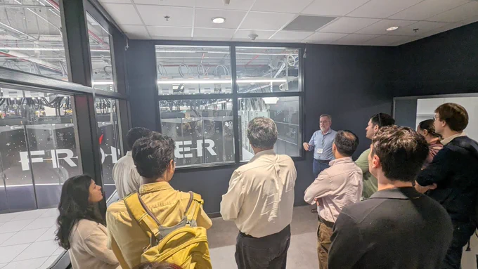 A group of people listening to a presenter at the Frontier supercomputer facility.