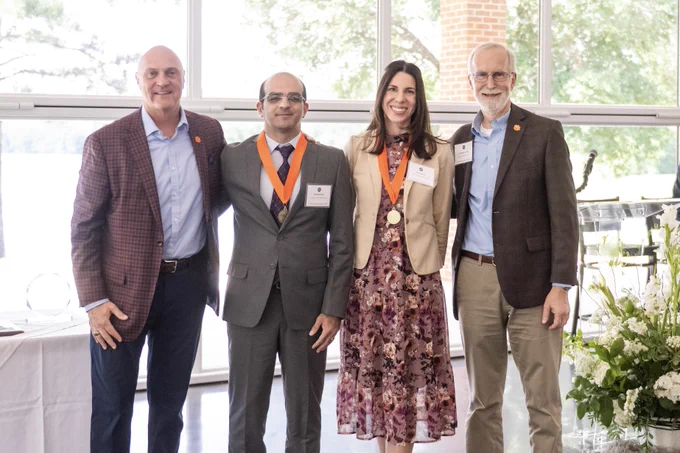 President Clements and Provost Jones posing for a photo with two award winners.