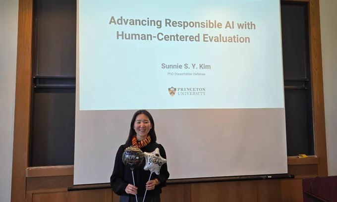Sunnie standing in front of her presentation celebrating the successful defense