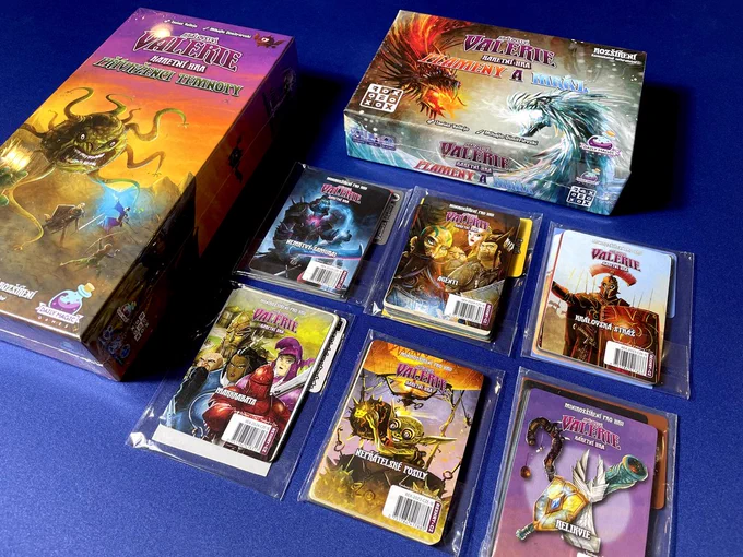 Two boxes and 6 packs of cards that are expansions to the card game Valeria Card Kingdoms all in Czech