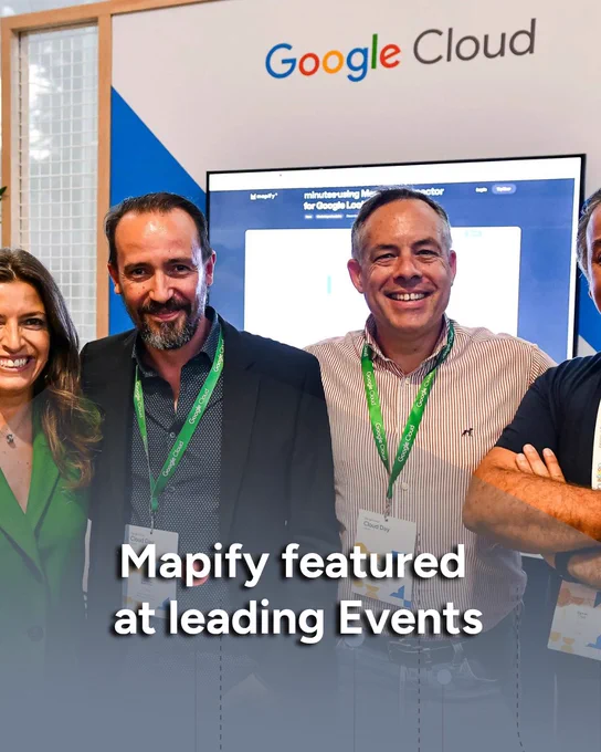 A group of Mapify team members pose in front of the Google Cloud booth at an international tech event.

