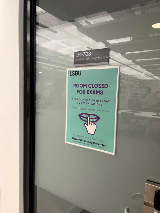 Photo of the exterior of the door of Assistive Technology Room 1 with a poster on it that says 'Room closed for exams, This room is closed today for examinations, Please keep all noise to a minimum, We apologise for any inconvenience'