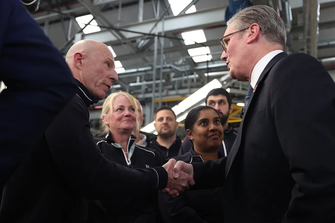 Prime Minister Keir Starmer shakes hands with a worker at Jaguar Land Rover.