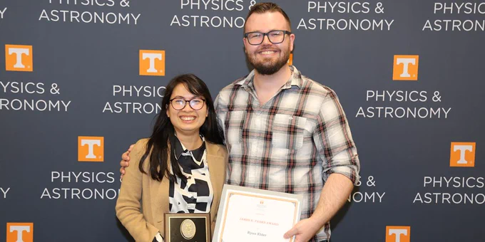 Photo of UT Physics Honors Day Awardees Dien Nguyen and Ryan Elder in front of a UT Physics background.