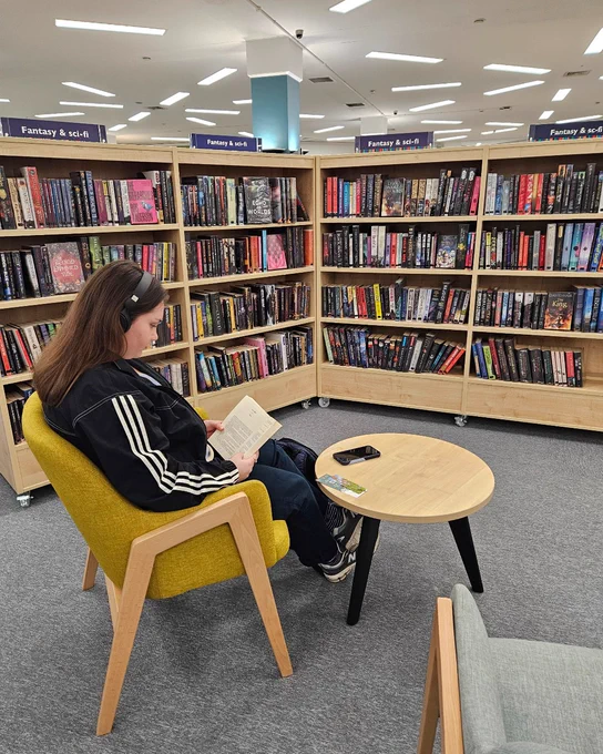 Person sitting in library with a book