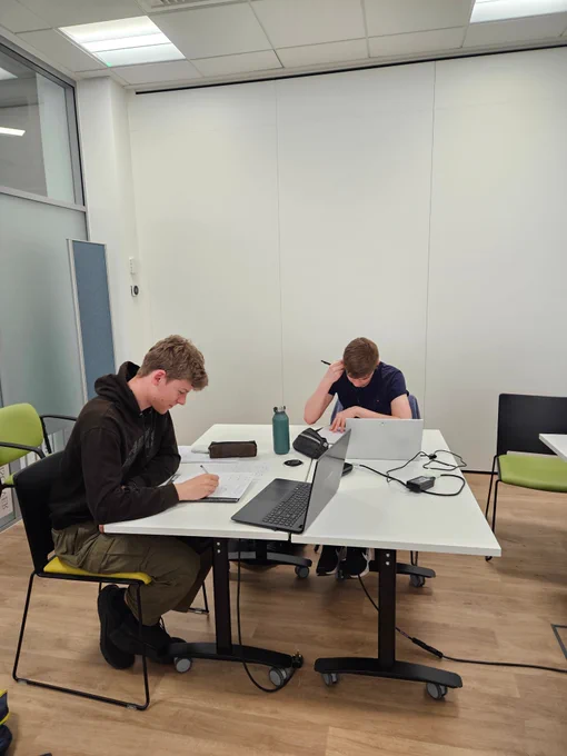 Two people with laptops studying