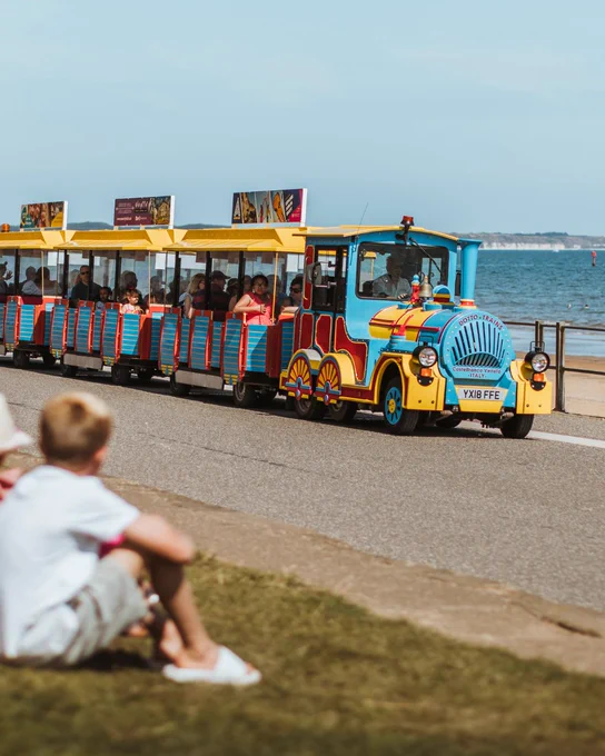 One of Bridlington's land trains travelling along the north promenade with Flamborough's cliffs visible in the background.