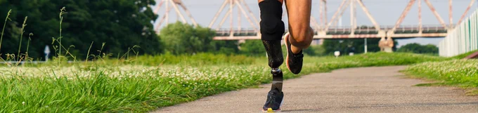 A person running, wearing a lower limb prosthetic.