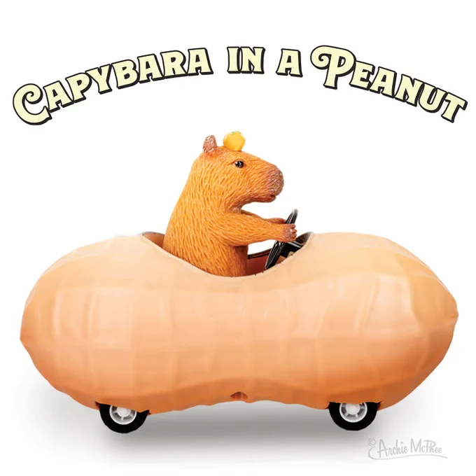 A toy car shaped like a peanut being driven by a capybara. 