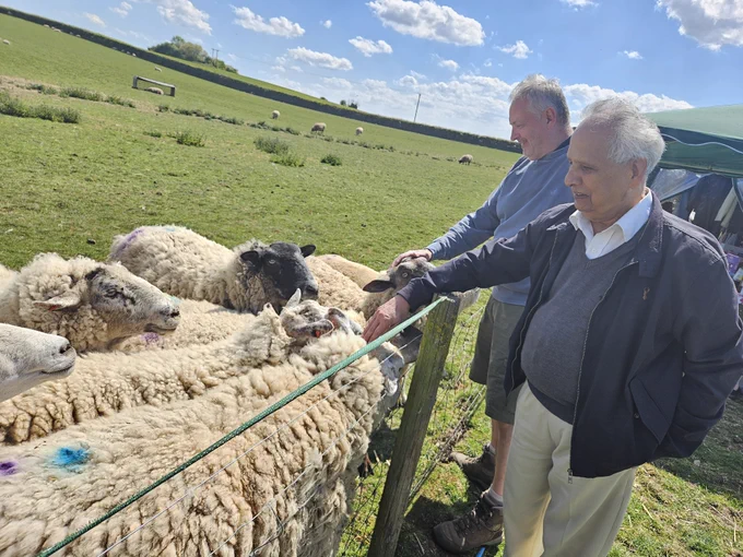 2 people spend time with friendly sheep at FARS open day