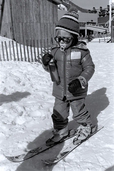 A child in the Lionshead base area of Vail wears skis, winter clothing and sunglasses as well as a pacifier.