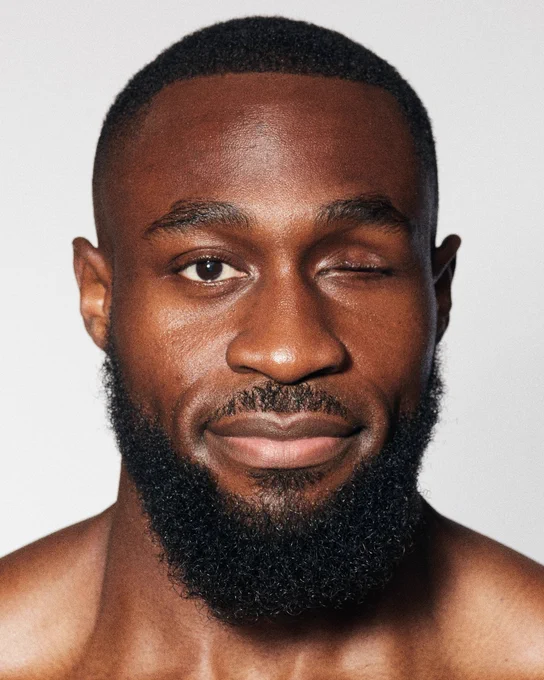 A professional headshot of Michael, a black man, with his left-eye closed.