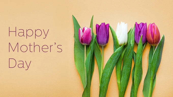 Happy Mother's Day text with a row of colorful tulips arranged on a light orange background.