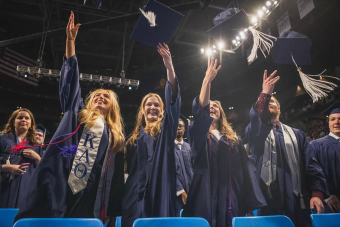 Group of college graduates throwing their caps