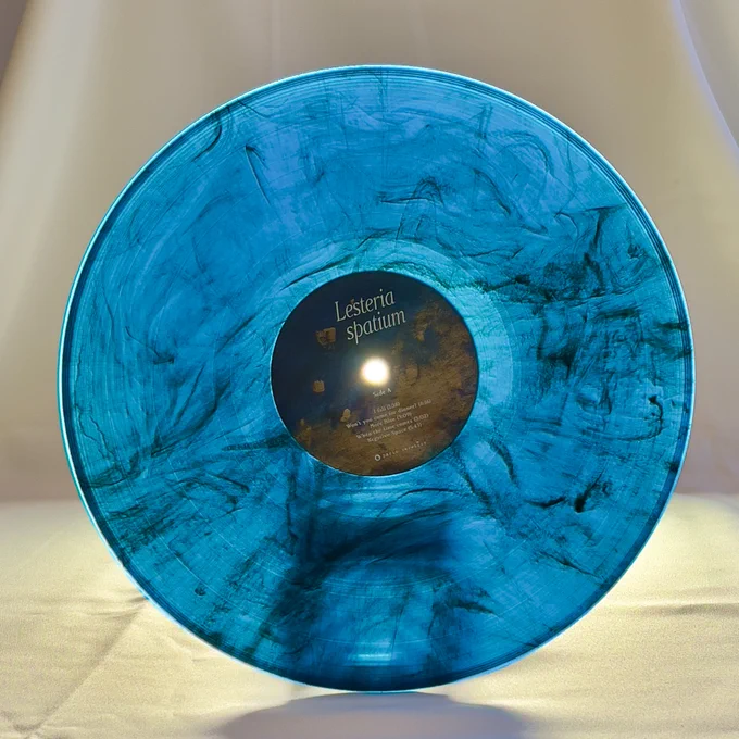 Detail shot of the limited edition blue marble vinyl of the Lesteria album, spatium, with light shining through it