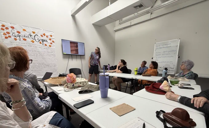 A workshop taking place at Writespace. People seated at tables listening to a speaker