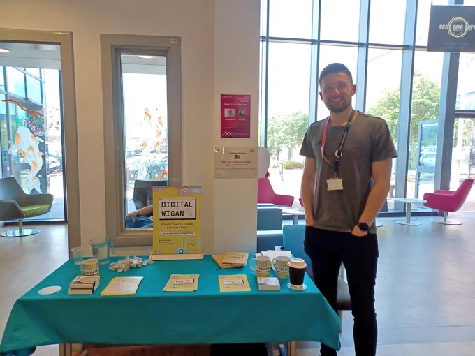 Alex next to a stall with leaflets on.