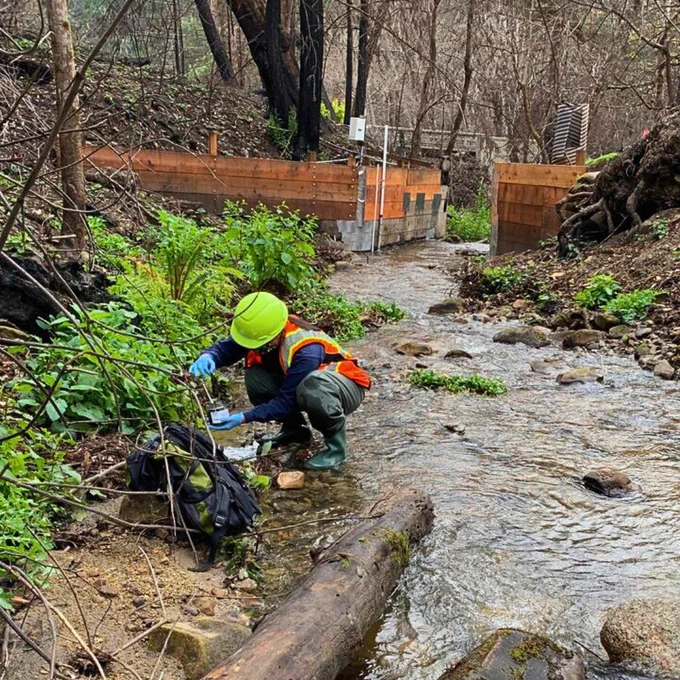 A USGS Research geologist samples stream sediment in the lower parts of a burned watershed. (Photo: Amy East, USGS) 