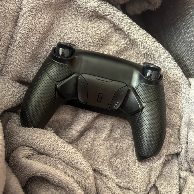Photo of the back of a Ps5 controller with paddles added to it