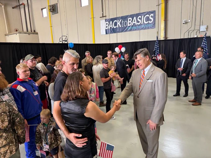 Deputy Secretary Landau shakes hands with newly arrived refugees