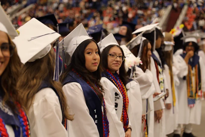 Graduates stand during their graduation ceremony.